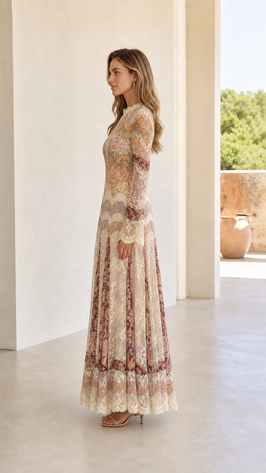Side profile view of model showcasing flowing silhouette of cream lace maxi dress