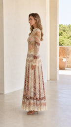 Side profile view of model showcasing flowing silhouette of cream lace maxi dress