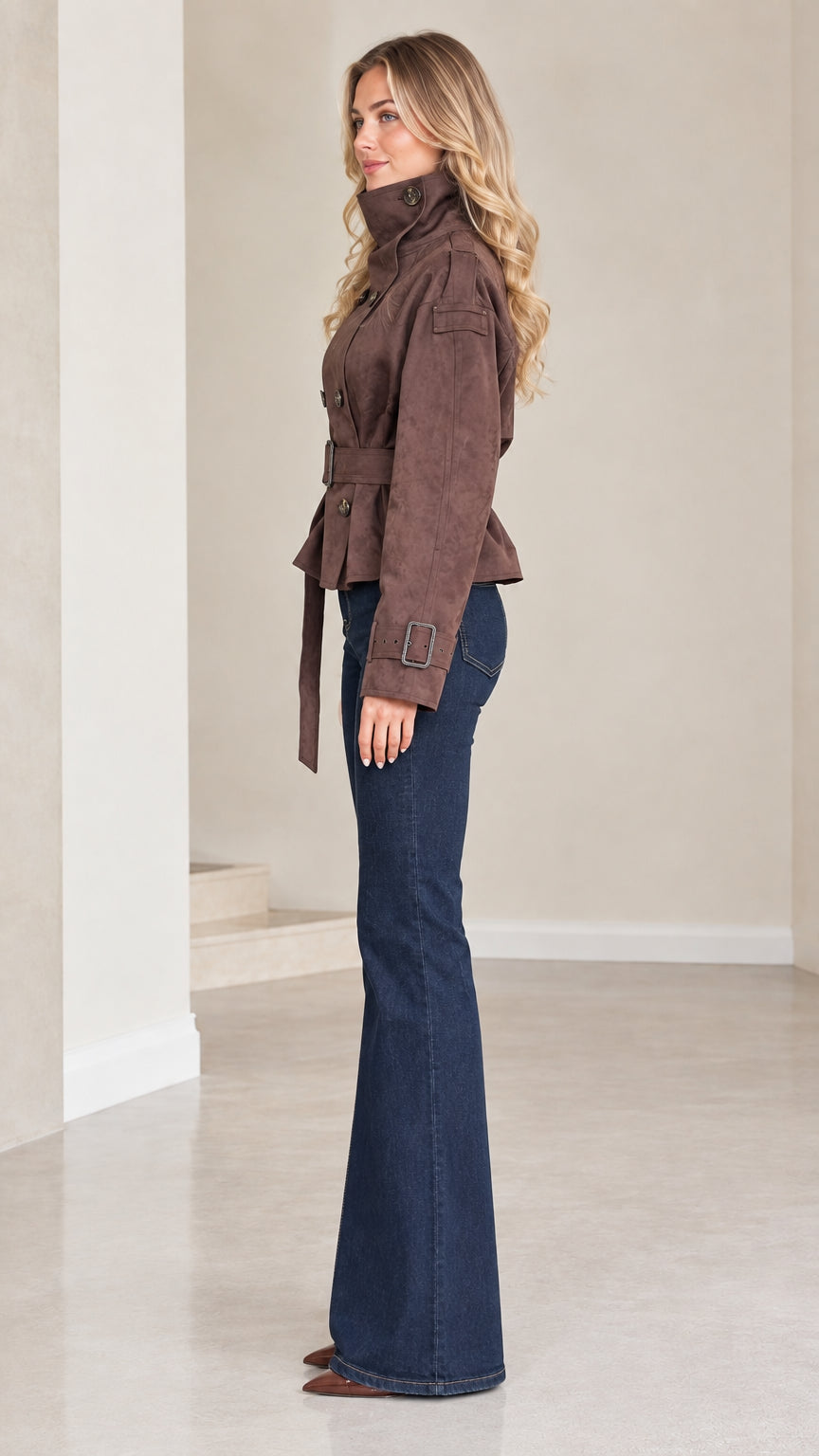 Side profile view of model wearing brown cropped belted jacket