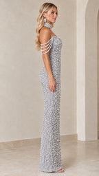 Side profile of model in a full-length silver beaded formal evening gown