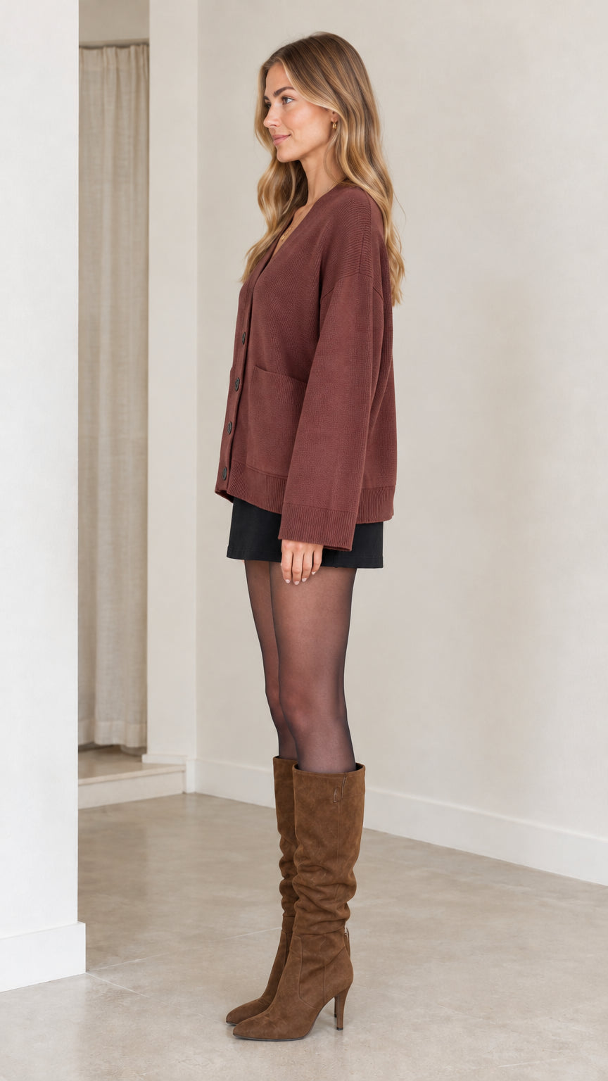 Side profile view of woman wearing brown button-down cardigan with dropped shoulders