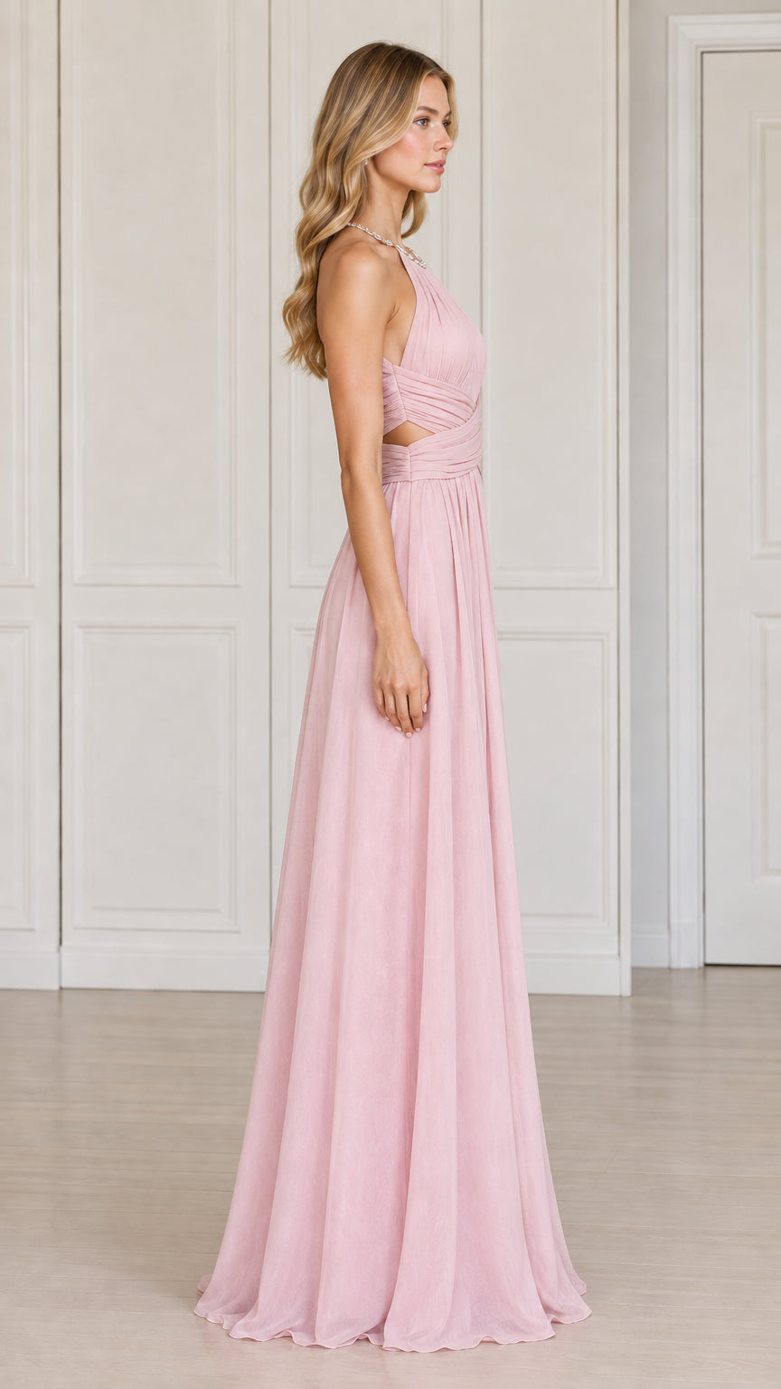 Side profile view of the blush pink halter evening gown showing side cutouts and pleated skirt