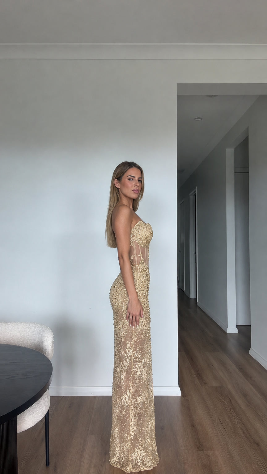 Side profile of model wearing Champagne Gold strapless corset maxi evening dress