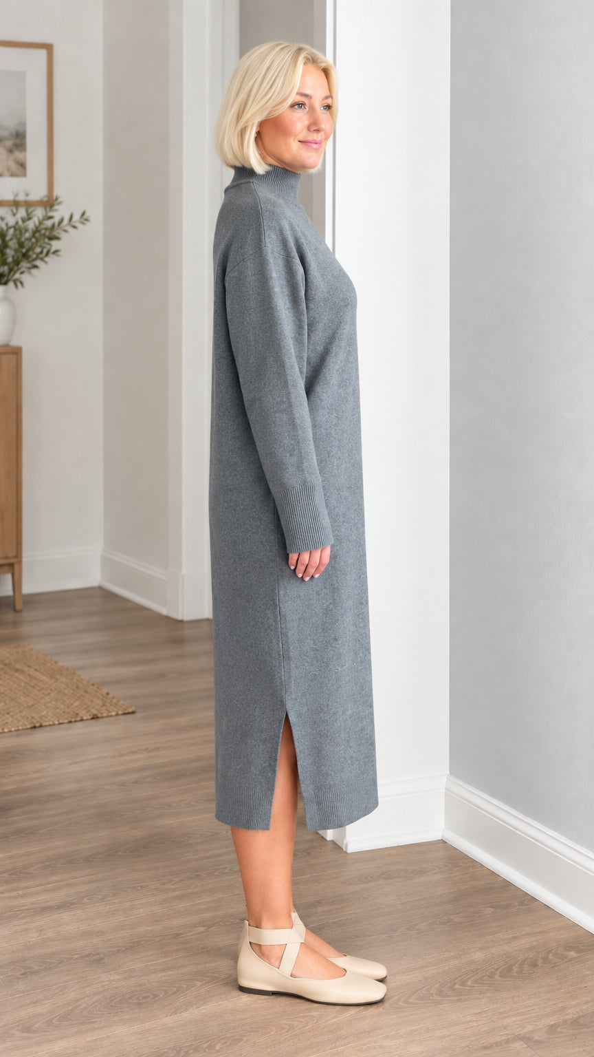 Side profile view of woman wearing slate grey knit midi dress with side hem slit
