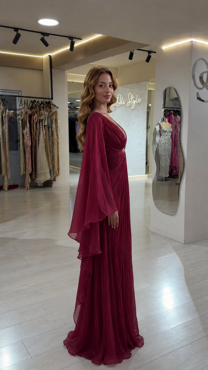 Side angle view of burgundy pleated cape sleeve formal maxi dress