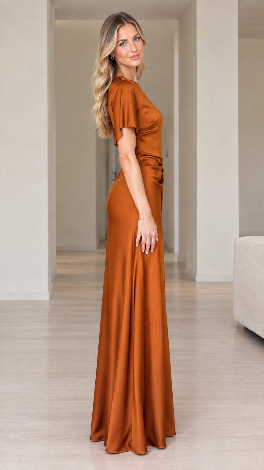 Side profile of woman wearing rust orange short sleeve satin gown