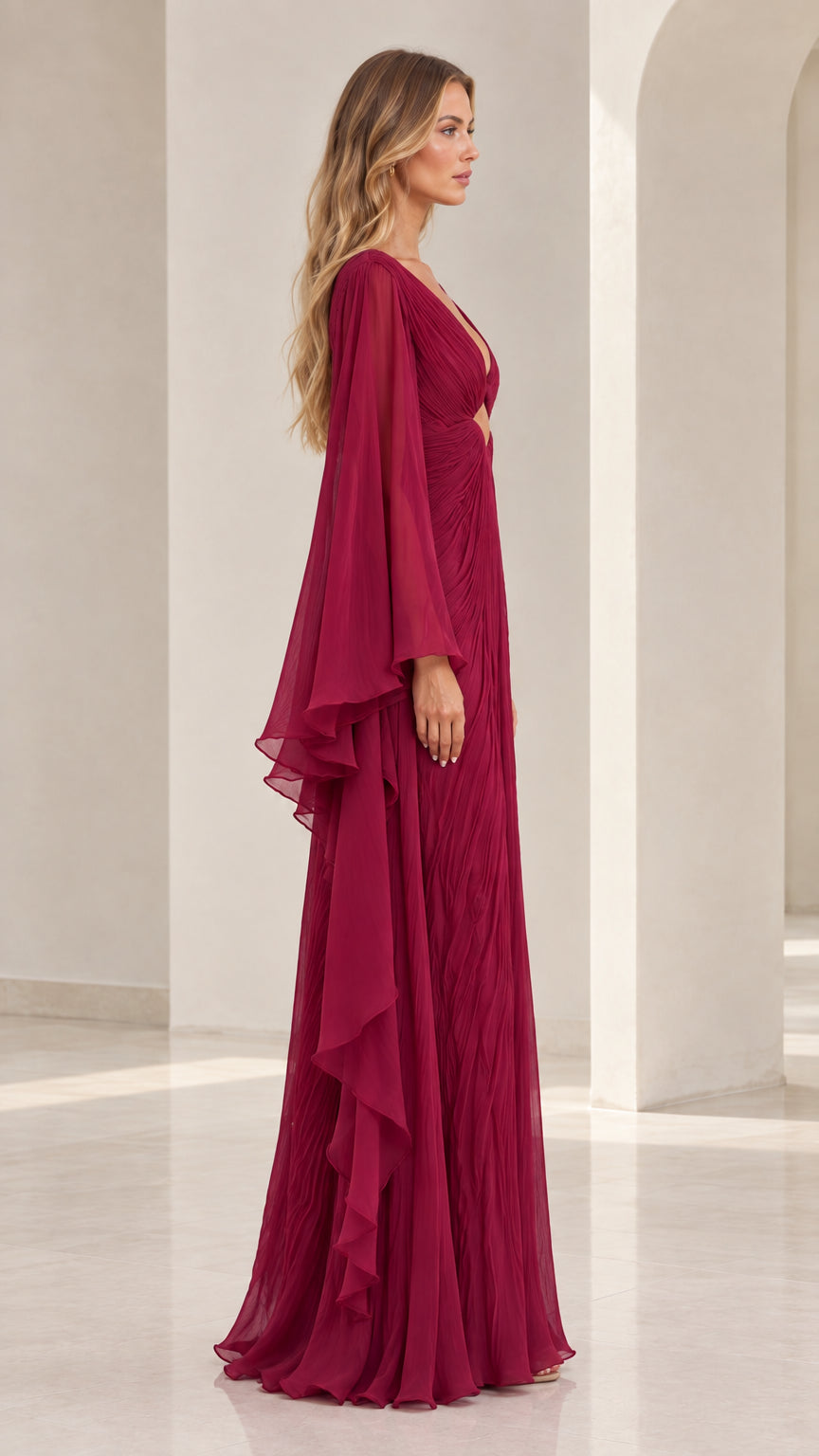 Side view of burgundy accordion pleated formal maxi gown showing sweeping sleeve drape