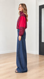 Side profile of woman in burgundy color-block lightweight windbreaker jacket