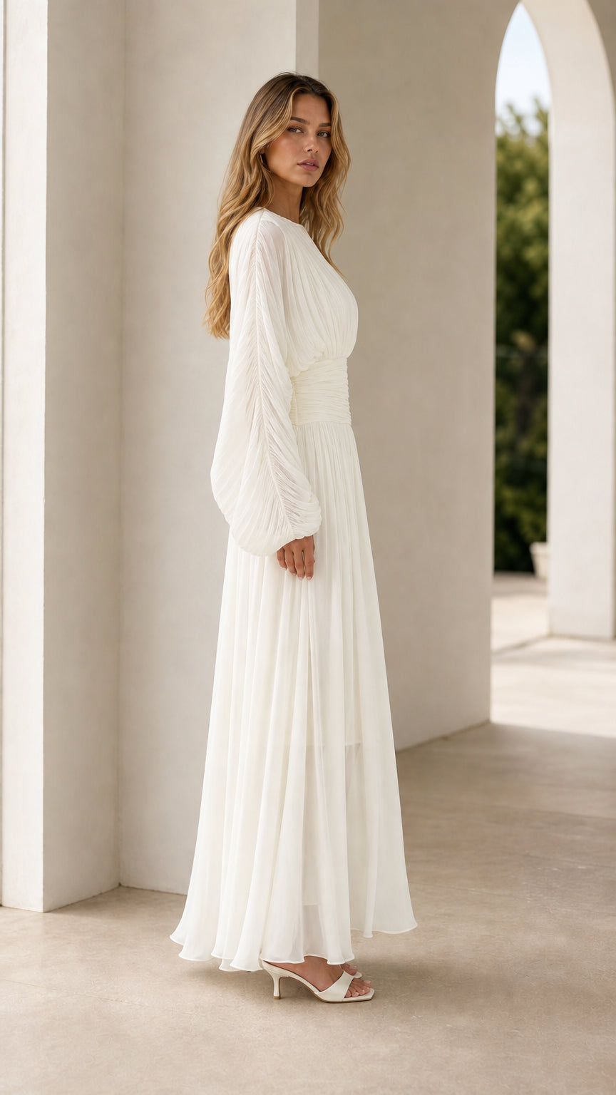 Side profile of white pleated maxi dress showing sleeve drape