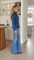 Side profile view of model wearing denim blue button-front structured jacket