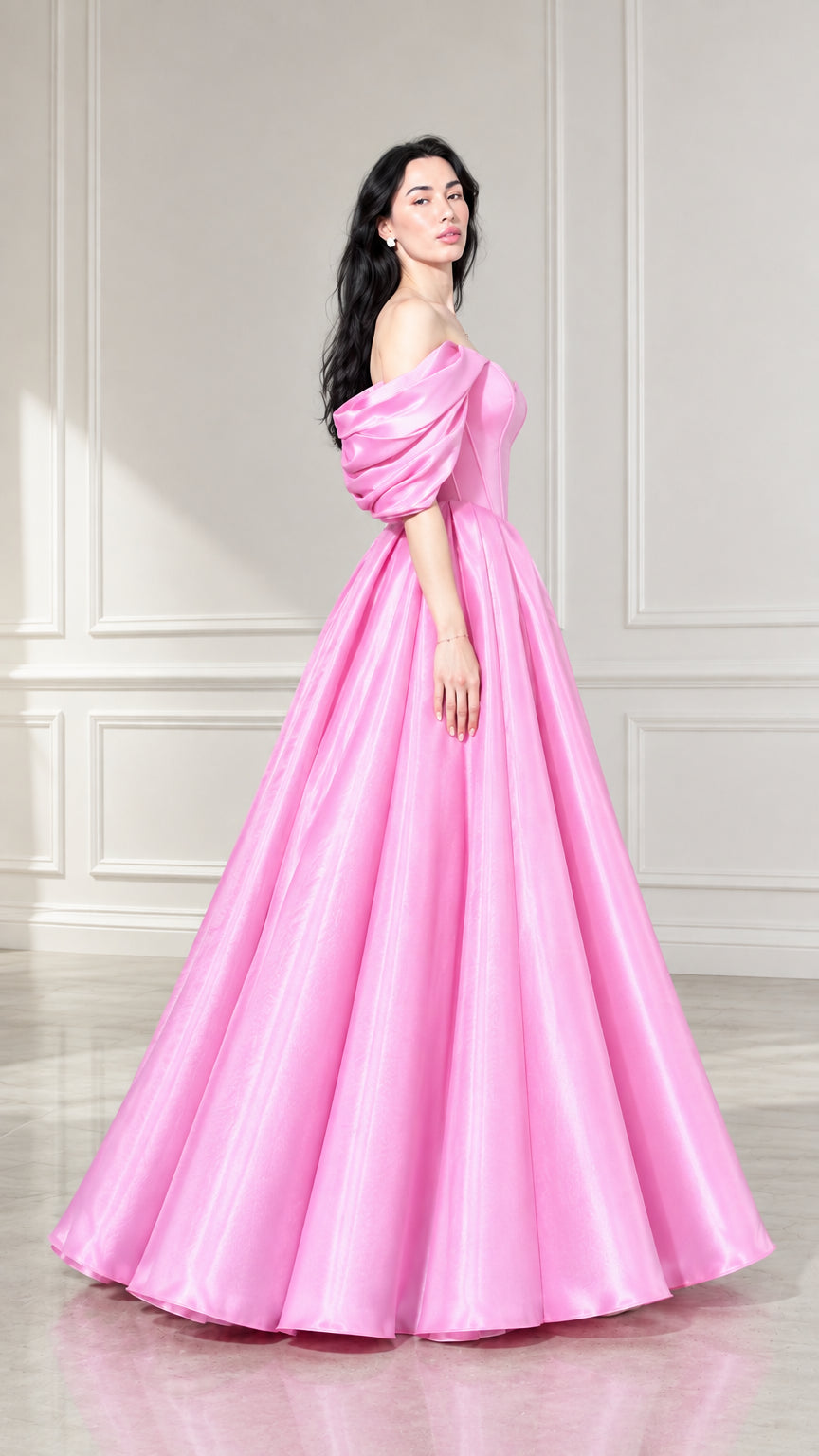 Side profile of woman modeling pink floor-length puff sleeve ball gown