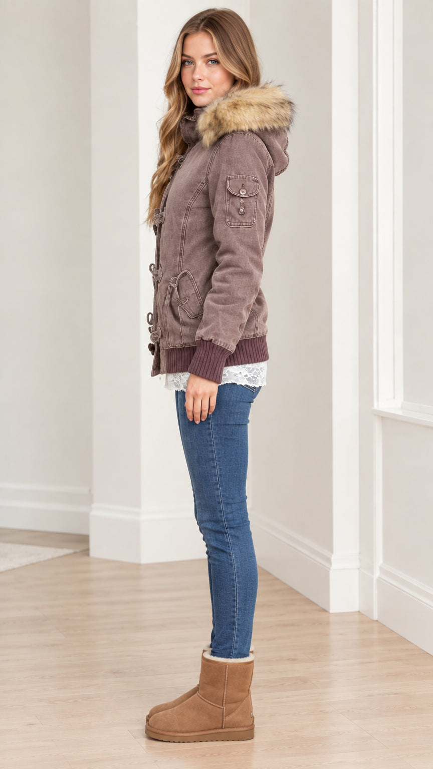 Side profile view of women's taupe brown hooded parka jacket paired with jeans and boots