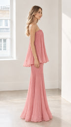 Side full-length view of dusty pink strapless pleated maxi gown showcasing draped tier silhouette