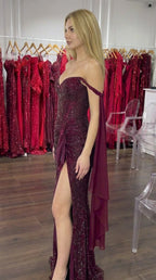 Side angle of model showcasing the waist ruching and leg slit on burgundy glitter formal gown