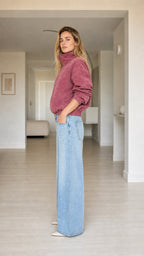 Side profile view of model wearing dusty rose stand collar zip-up plush jacket
