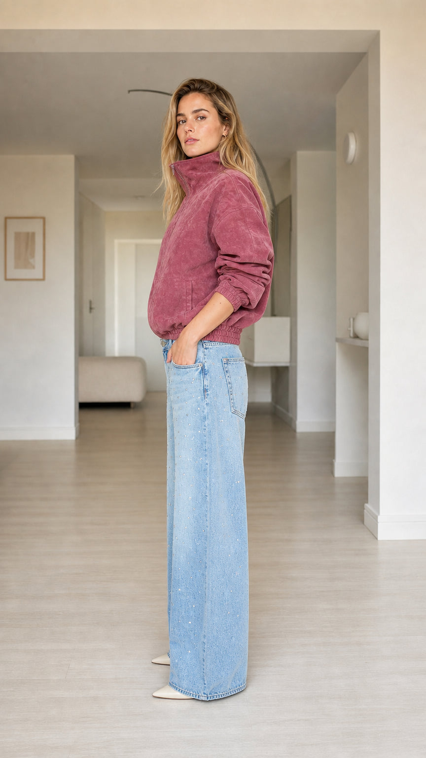 Side profile view of model wearing dusty rose stand collar zip-up plush jacket