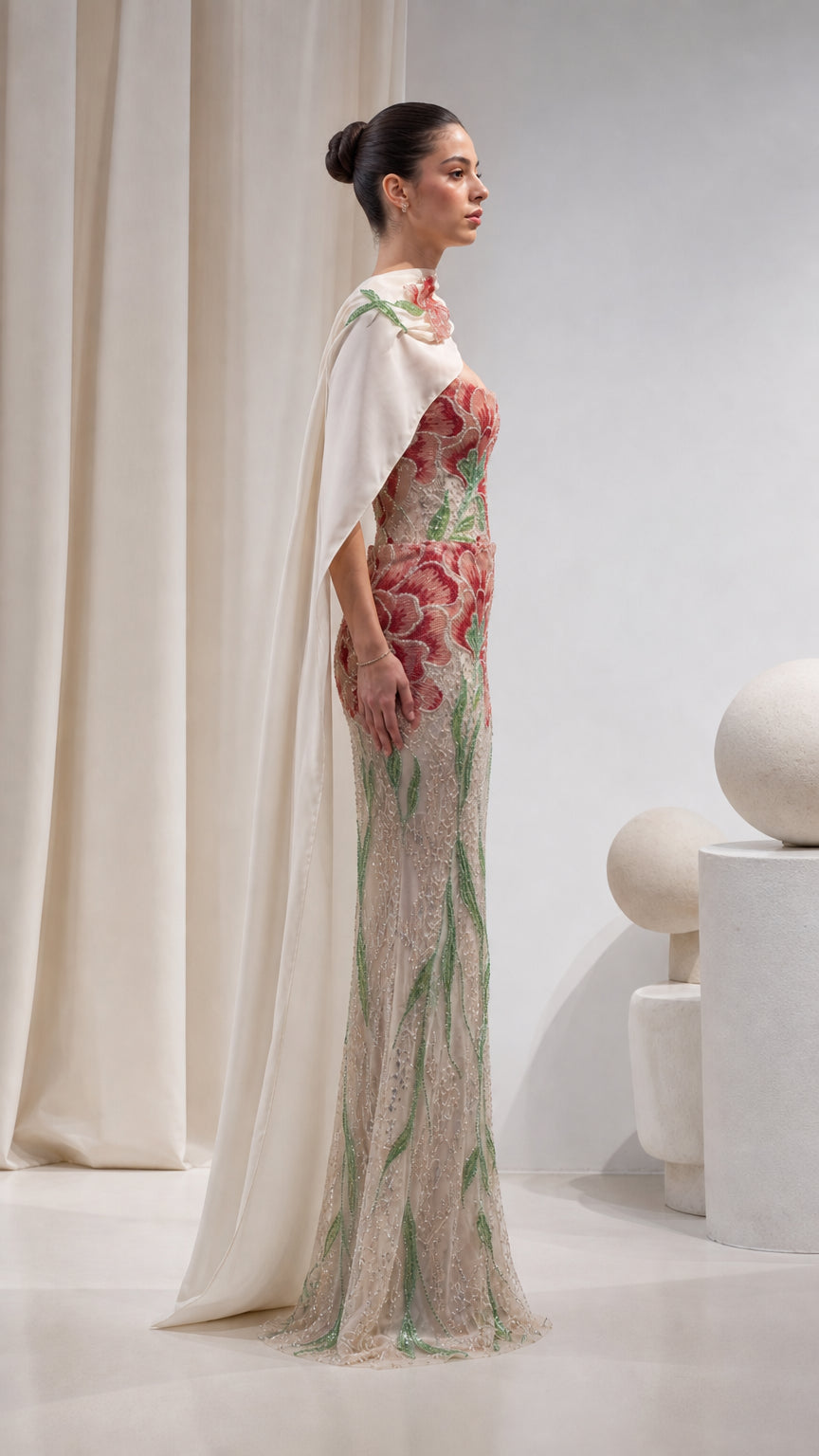 Side profile of Champagne beaded evening gown showing cape drape and mermaid silhouette