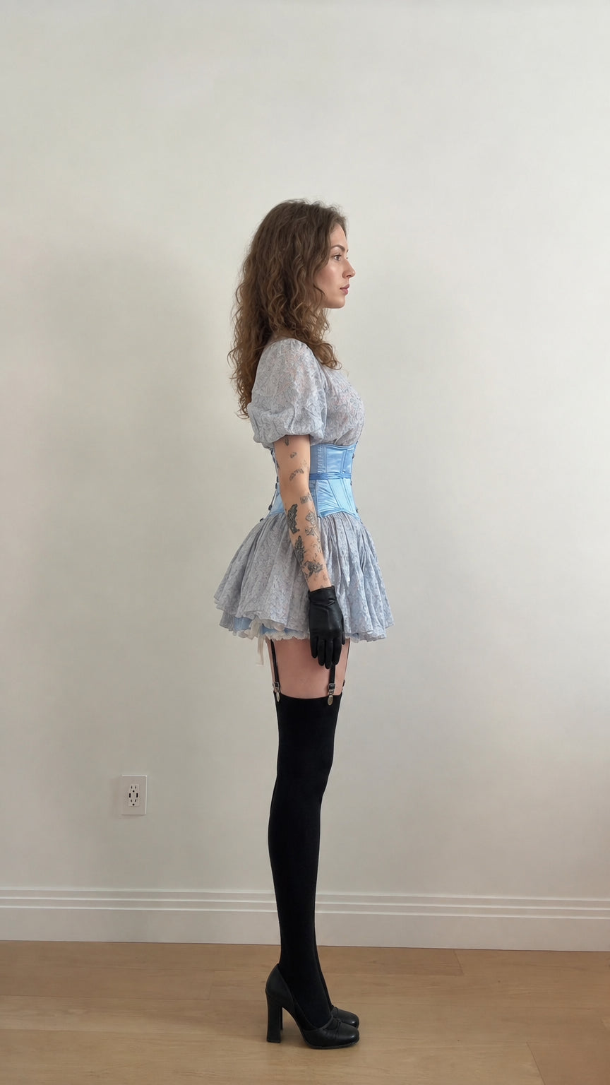 Side profile view of light blue puff sleeve mini dress showing fit and tiered skirt flare