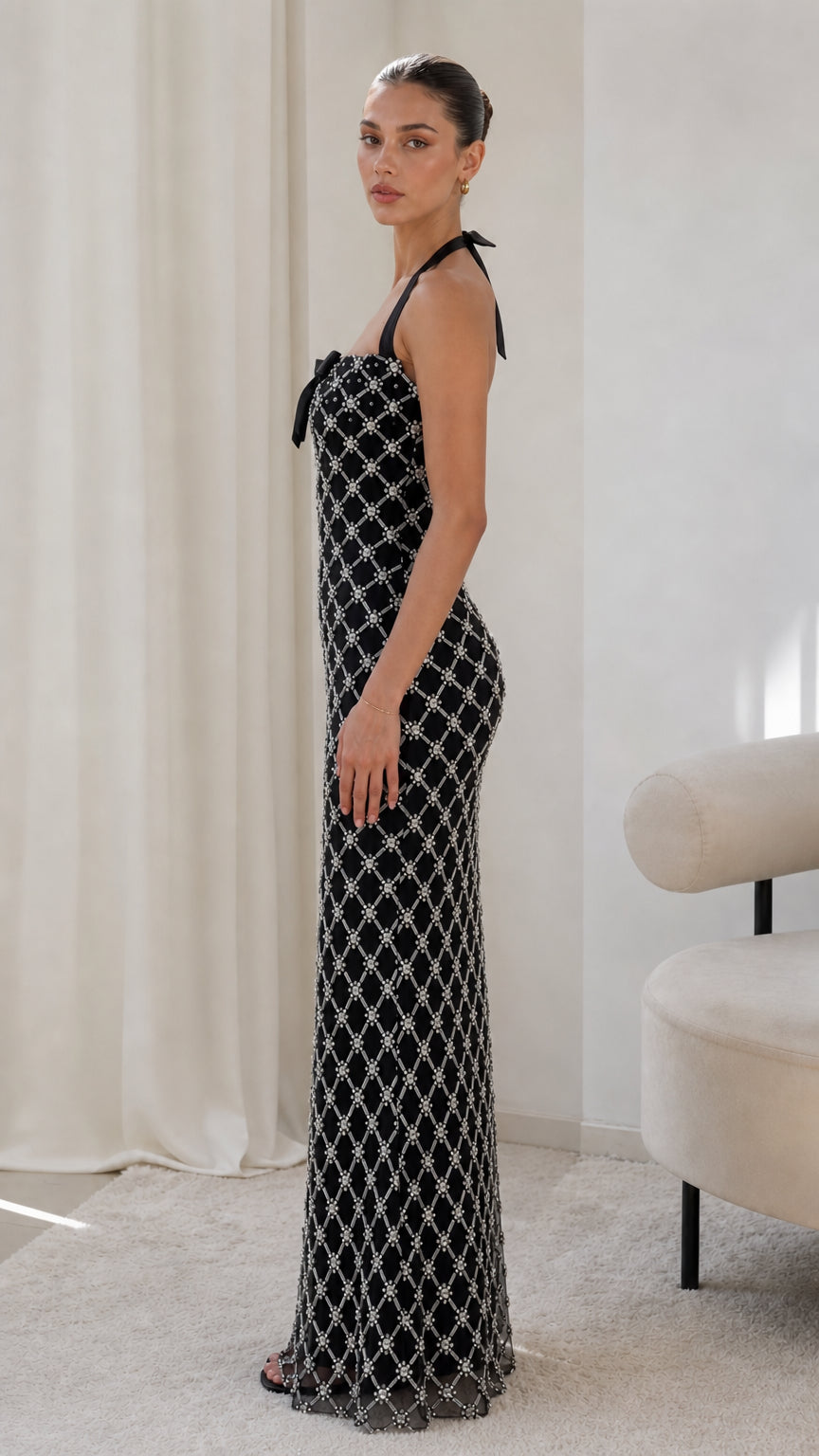 Side profile of model wearing black beaded halterneck evening gown