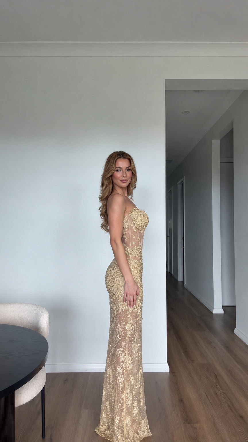 Side profile view of gold sheer corset formal evening gown