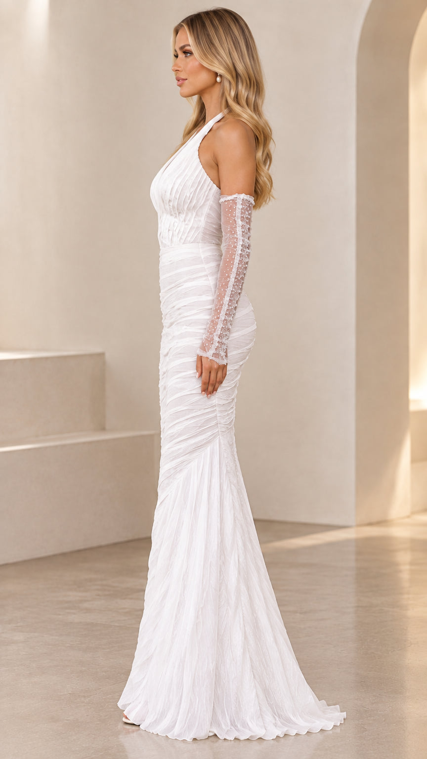 Side profile of woman in white ruched halter mermaid gown highlighting the fitted silhouette