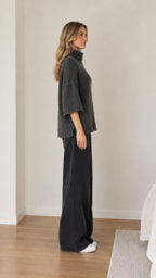 Side profile view of dark grey turtleneck sweater with elbow-length sleeves