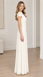 Side full-length view of woman wearing ivory ruched bodice drop-waist maxi dress