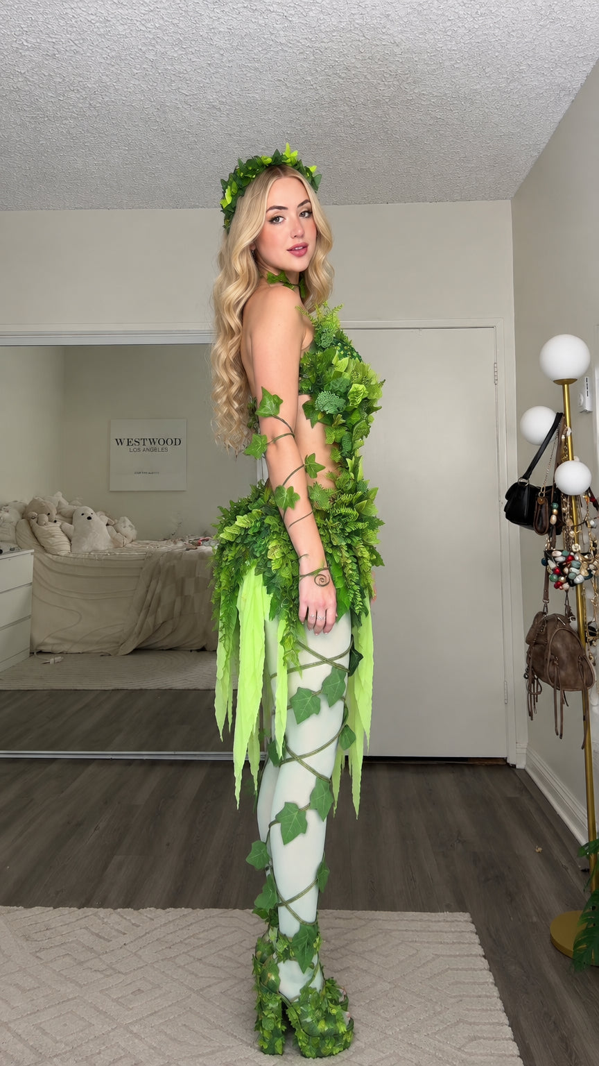 Side profile view of green woodland ivy fairy costume highlighting foliage detail and layered ribbons