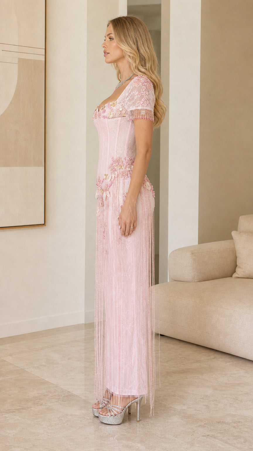 Side profile of model in Light Pink beaded corset evening gown with fringe overlay