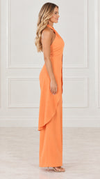 Model wearing orange halter tunic and wide leg trousers, side profile view