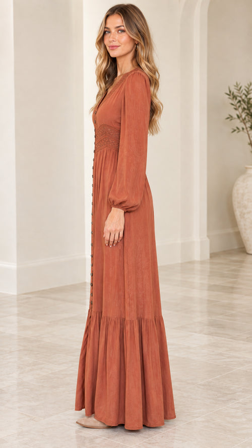 Side profile view of woman wearing rust orange long sleeve tiered maxi dress