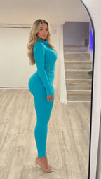 Side profile view of woman wearing teal two-piece activewear set