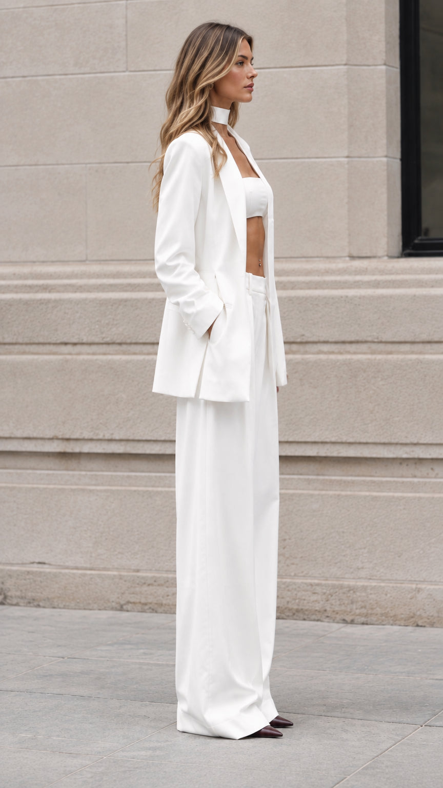 Side profile view of white three-piece tailored pantsuit set showing long fluid drape