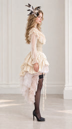Side profile view of cream Victorian corset dress showing tiered high-low ruffled skirt