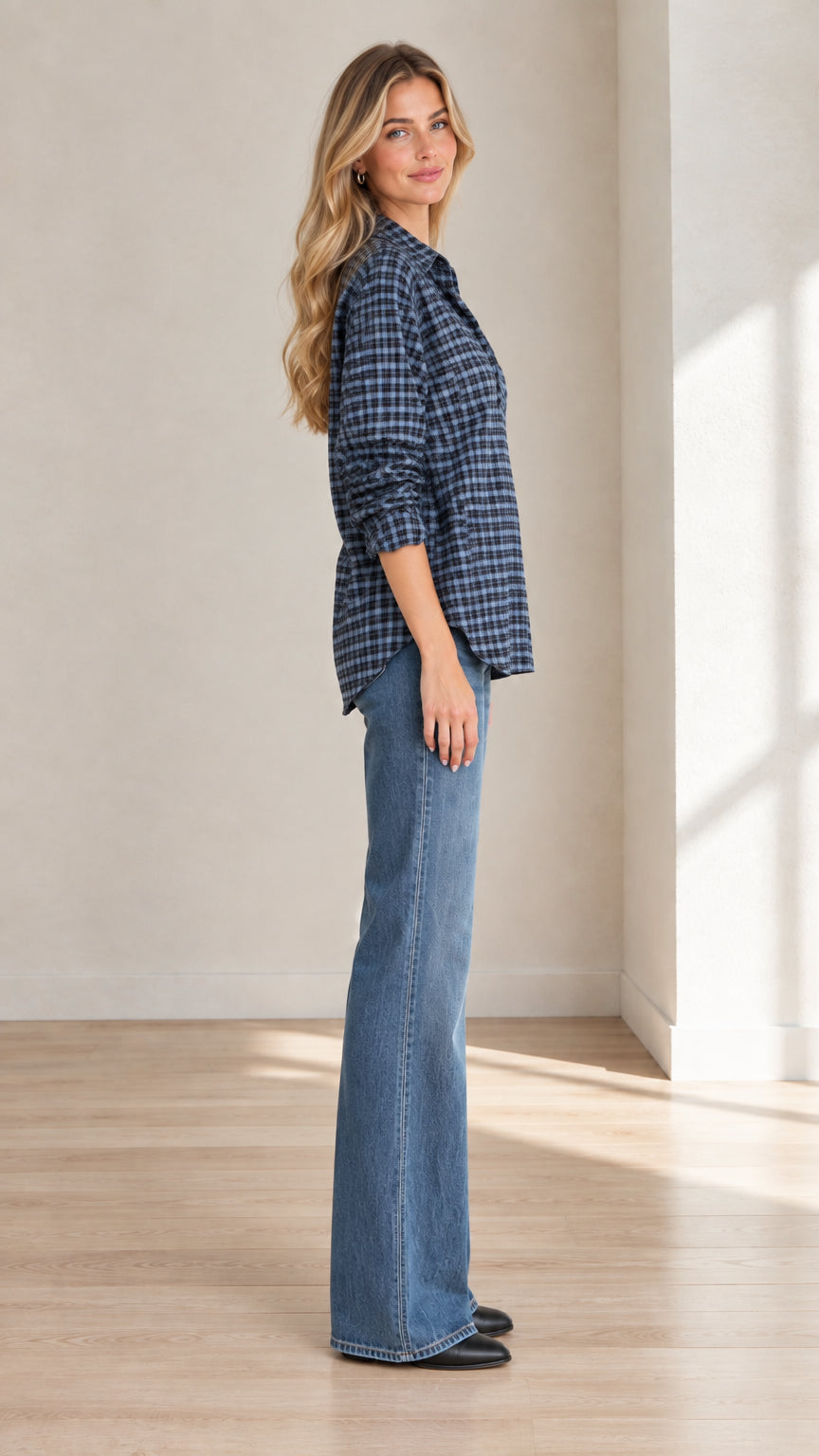 Side profile view of model in blue checkered V-neck tunic blouse