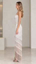 Side profile of model wearing champagne strapless beaded tiered evening dress