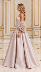 Side profile of model wearing dusty pink strapless ball gown showing dramatic skirt silhouette