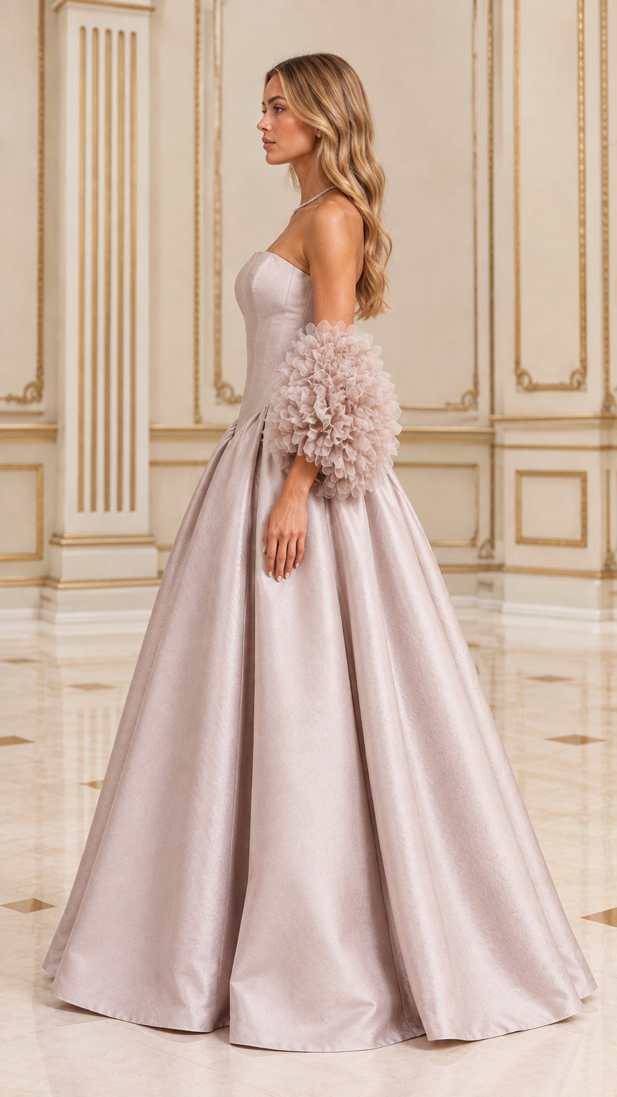 Side profile of model wearing dusty pink strapless ball gown showing dramatic skirt silhouette