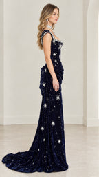 Side profile of model showing draped hip and sweeping train on midnight blue velvet evening gown
