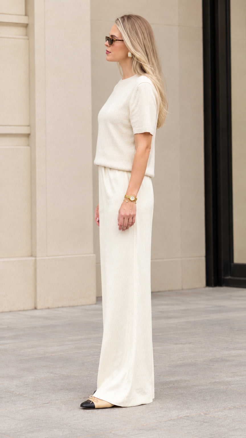Side profile view of women's cream matching knit two-piece lounge set