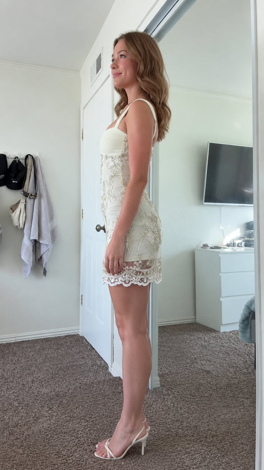 Side profile of model in butter yellow sequin embroidered mini dress with scalloped hem