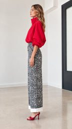 Side angle view of red top and animal print wide-leg trousers set