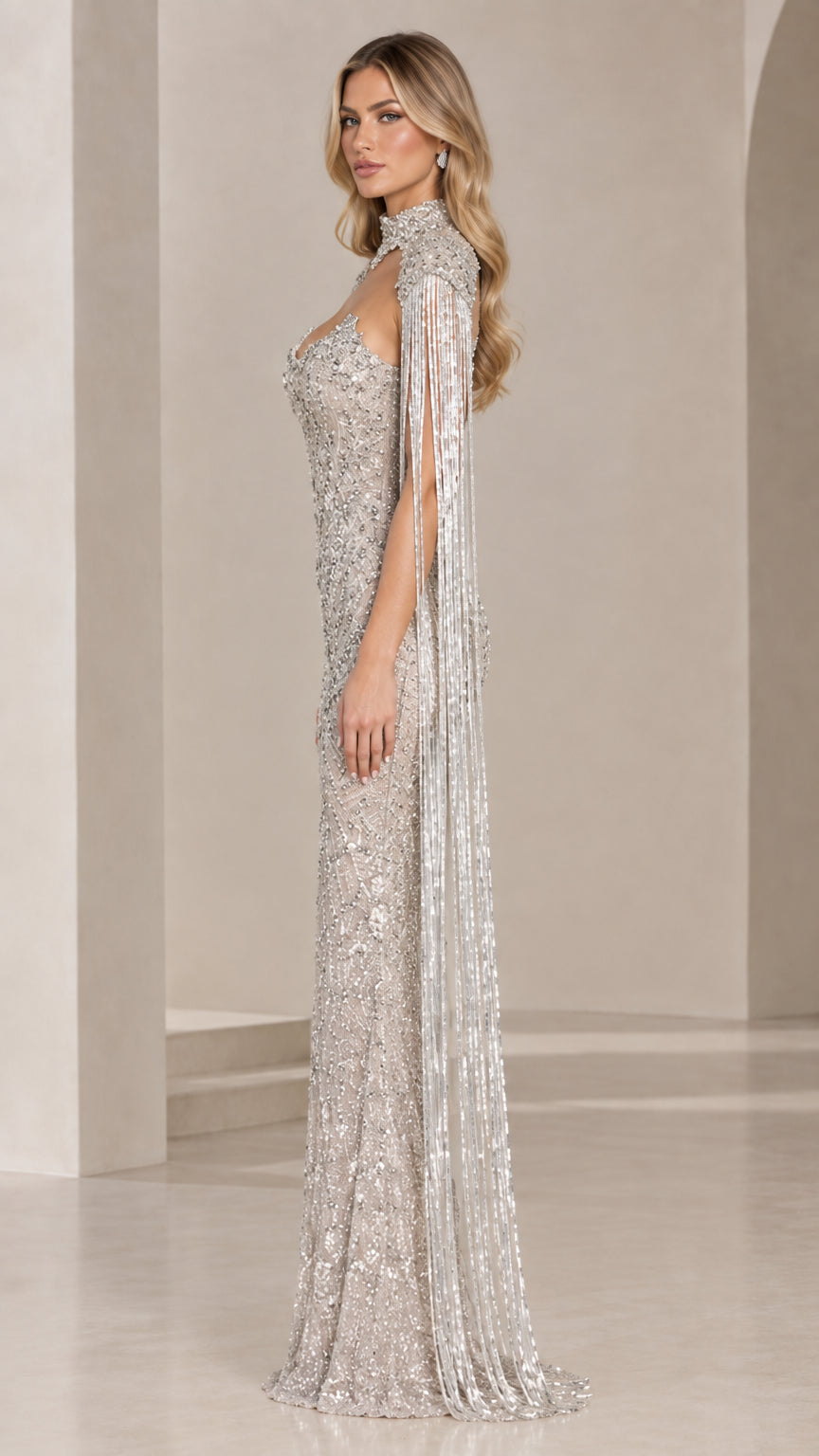 Side profile view of silver beaded gown showcasing the floor-sweeping beaded fringe cape sleeves