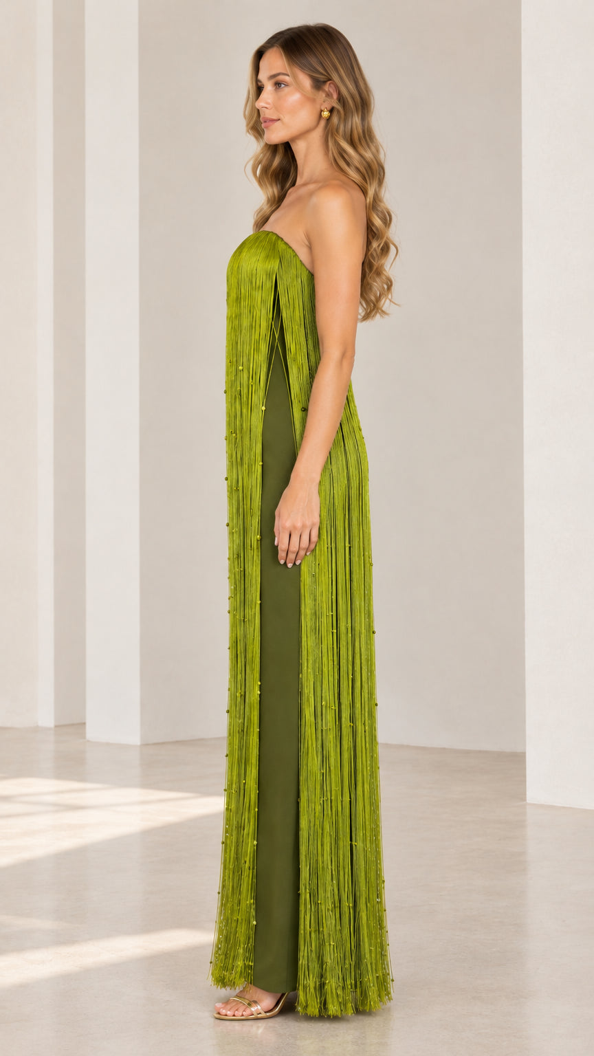 Side profile view of strapless olive green tassel gown showing slit detail