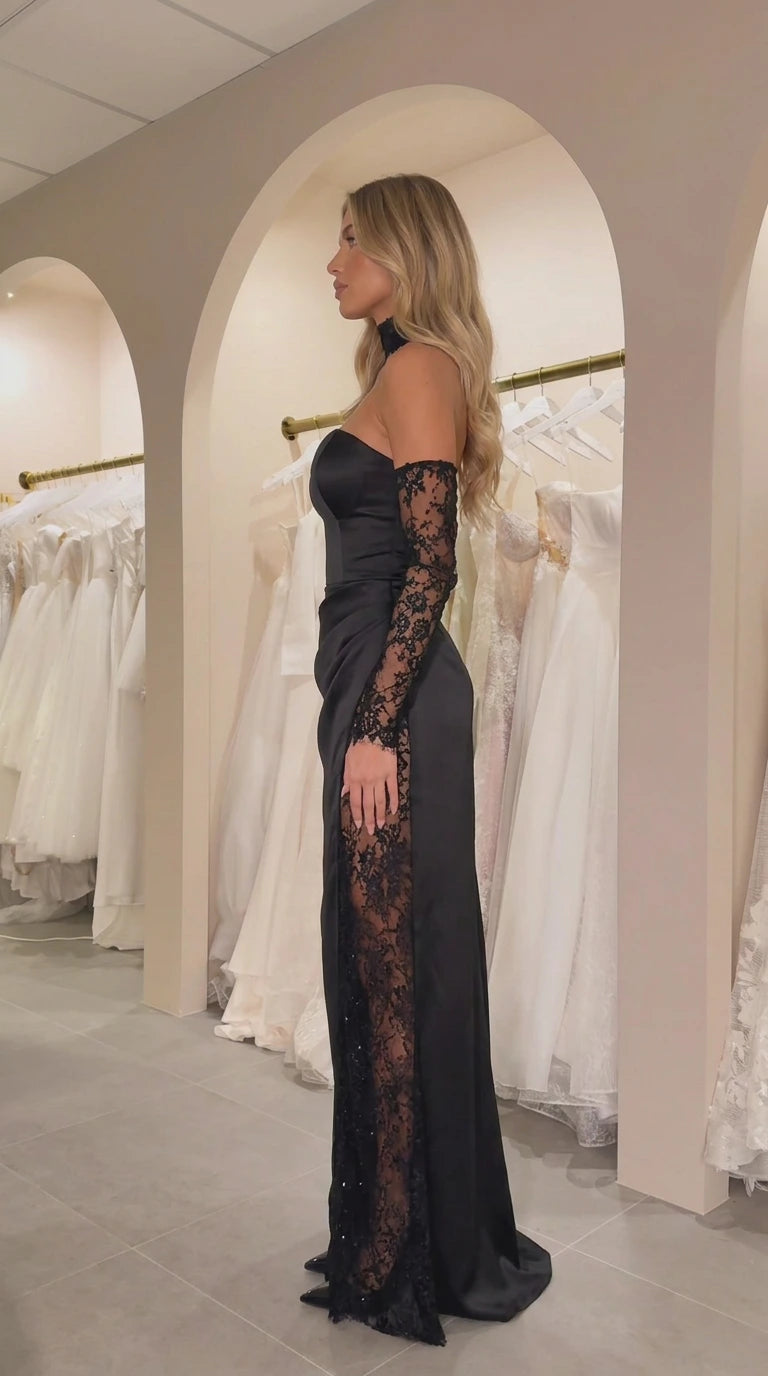Side profile view of black satin gown showing ruched hip and lace slit