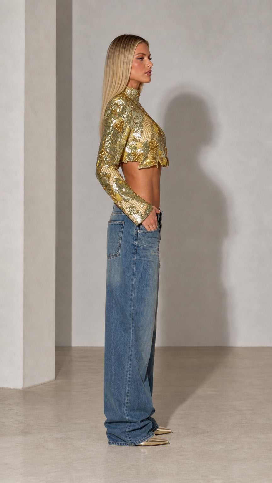 Side profile view of gold long sleeve sequin crop top