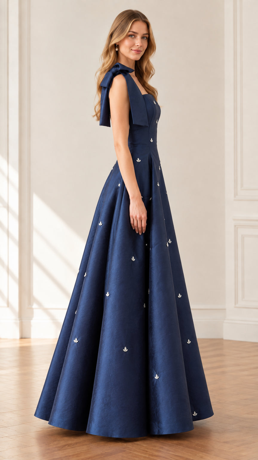 Side profile view of woman modeling navy blue square neck bow strap formal evening gown