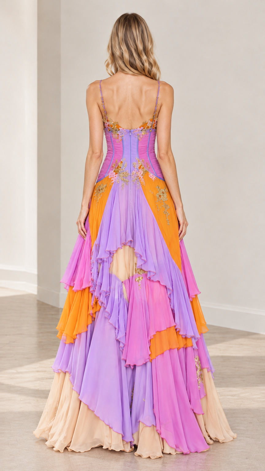Back view of model in multicolor tiered ruffle evening gown showing open back design