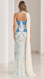 Back view of ivory strapless evening dress with blue floral accents and flowing cape drape