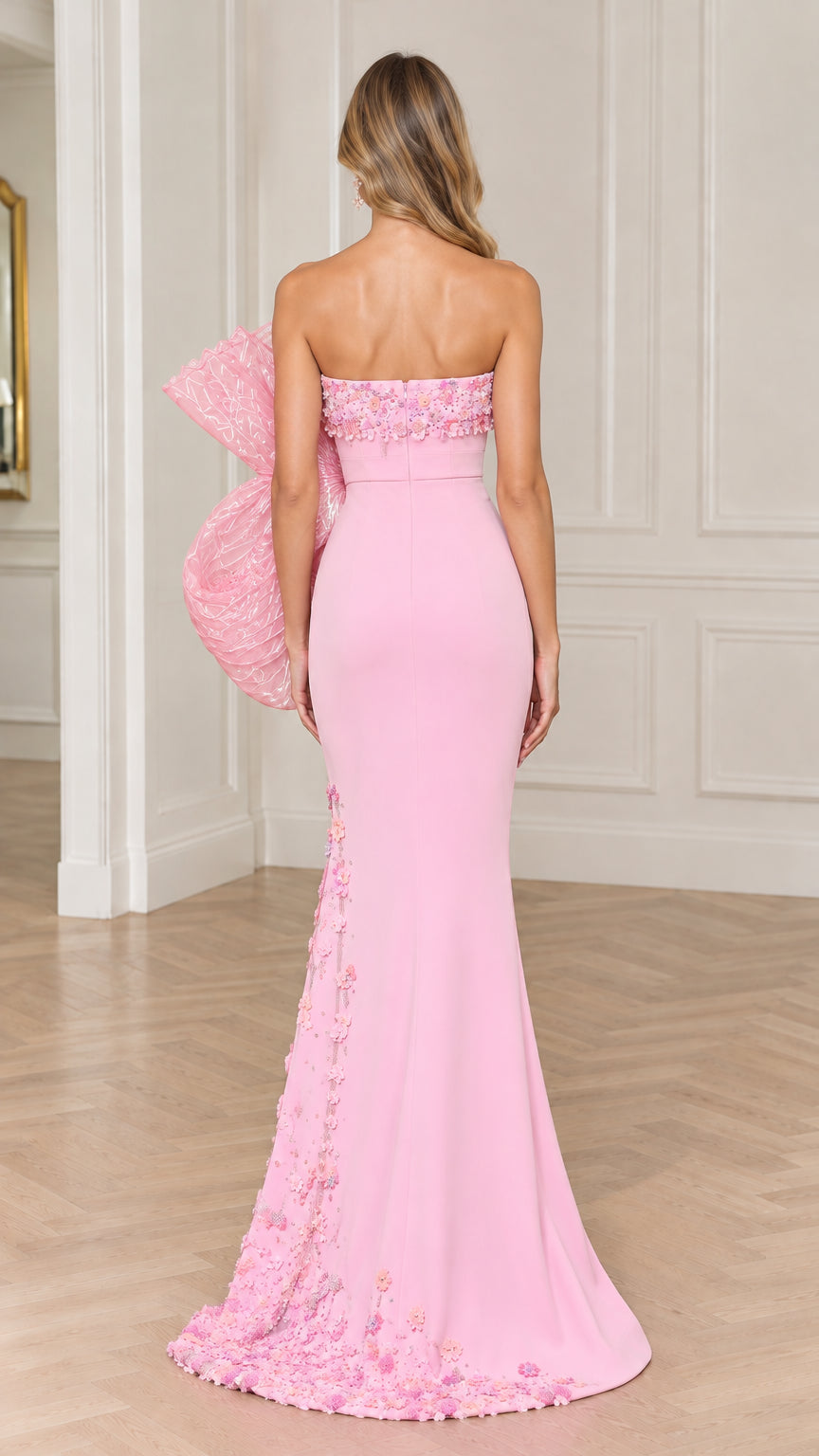 Back full view of pink strapless evening gown showing oversized bow and train